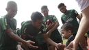 Pemain Timnas Indonesia U-23, Hanif Sjahbandi, menyapa seorang anak yang datang ke Stadion Madya, Jakarta, Rabu (13/3). Sejumlah anak dari Yayasan Rumah Harapan Indonesia datang menemui Timnas U-23 (Bola.com/Vitalis Yogi Trisna)