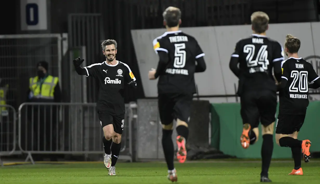 Gelandang tim Divisi 2 Holstein Kiel, Fin Bartels (kiri) merayakan gol penyeimbang 1-1 yang dicetaknya ke gawang Bayern Munich dalam laga babak kedua Piala DFB Pokal 2020/21 di Kiel, Rabu (13/1/2021). Holstein Kiel menang atas Bayern Munich lewat adu penalti 5-6 (2-2). (AFP/Fabian Bimmer/Pool)