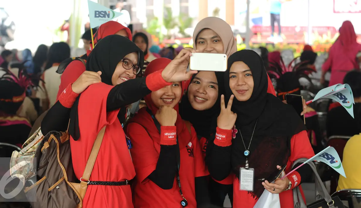 Salah satu peserta Lomba Senam Poco-Poco Nusantara berswadaya foto jelang berlomba dihalaman Kemenpora, Jakarta, Jumat (12/2/2016). Lomba ini memperebutkan piala Ibu Negara RI dan piala Menpora. (Liputan6.com/Helmi Fithriansyah)