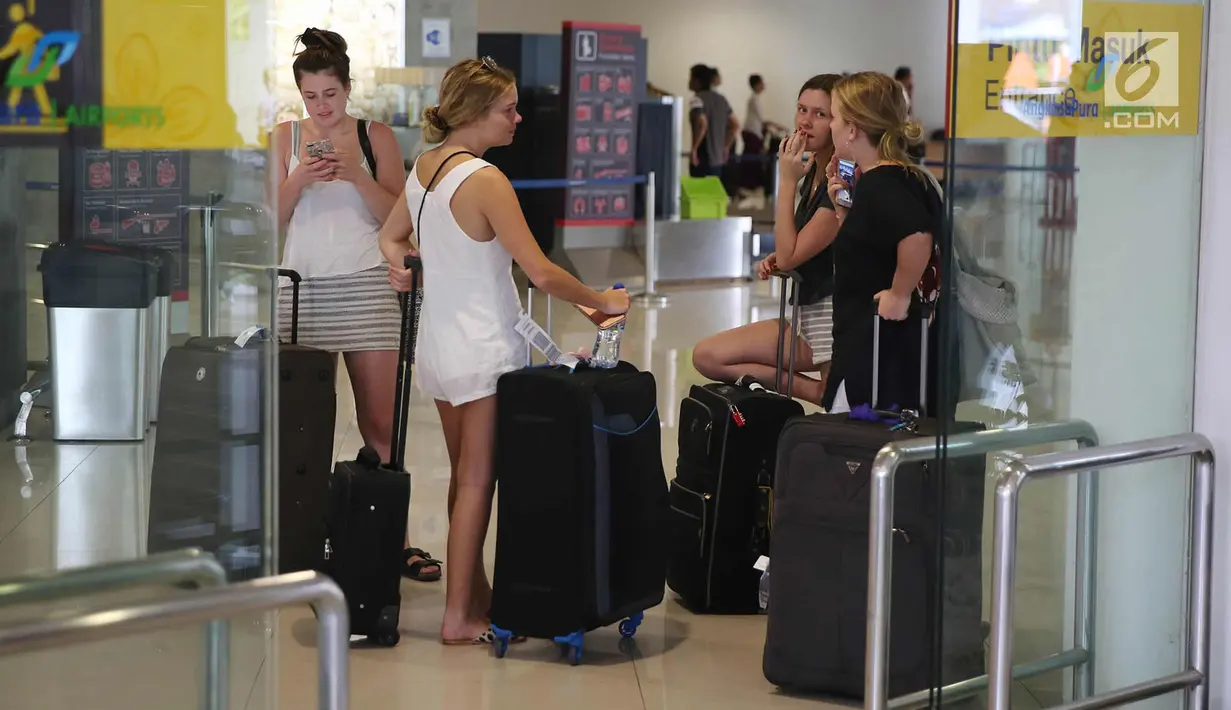 Calon penumpang menunggu keberangkatan di Bandara Internasional I Gusti Ngurah Rai, Bali, Kamis (30/11). Aktivitas kedatangan dan keberangkatan Bandara Internasional I Gusti Ngurah Rai sudah beroperasi dengan normal. (Liputan6.com/Immanuel Antonius)
