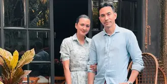 Donna Agnesia dan Darius Sinatria kompak mengenakan baju bernuansa baby blue. Donna mengenakan long dress baby blue bermotif model kerah dipadukan heels putih serasi dengan handbagnya. [@dagnesia]