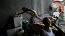 Seorang anak mengambil makanan dirumahnya yang hanya berlindung jembatan di Sao Paulo, Brasil, (18/12). Mereka adalah keluarga tunawisma yang tinggal di bawah jembatan. (REUTERS/Nacho Doce)