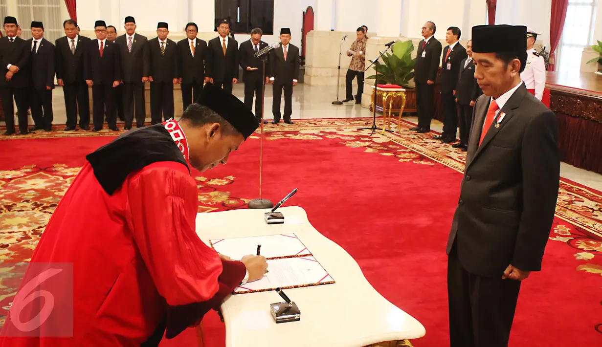 Hakim Mahkamah Konstitusi (MK) yang baru, Saldi Isra disaksikan Presiden Joko Widodo  menandatangani dokumen pelantikan sebagai Hakim MK di Istana Negara, Jakarta, Selasa (11/4). Saldi Isra menggantikan Patrialis Akbar. (Liputan6.com/Angga Yuniar)