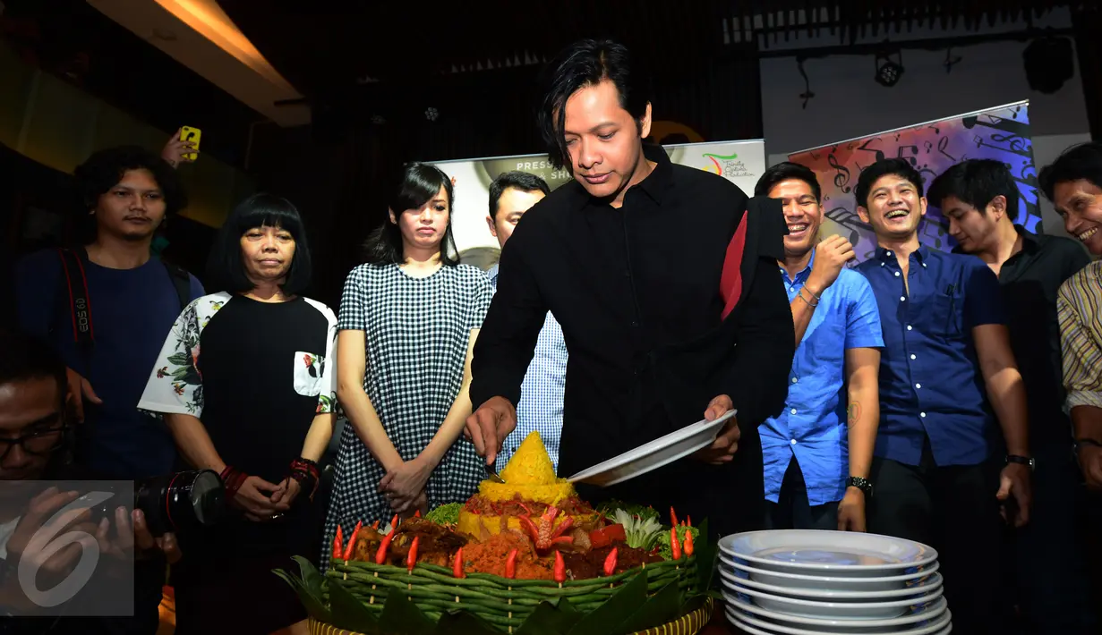 Penyanyi Armand Maulana memotong tumpeng saat merilis single solonya yang berjudul "Hanya Engkau Yang Bisa" di kawasan SCBD, Jakarta, Selasa (5/4). Lagu tersebut diciptakan dan diaransemen oleh personel Maliq 'n D Essential. (Liputan6.com/Herman Zakharia)