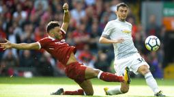 Gelandang Liverpool, Alex Oxlade-Chamberlain, berebut bola dengan bek Manchester United, Matteo Darmian, pada laga Premier League di Stadion Anfield, Sabtu (14/10/2017). Liverpool bermain imbang 0-0 dengan Manchester United. (AP/Rui Vieira)