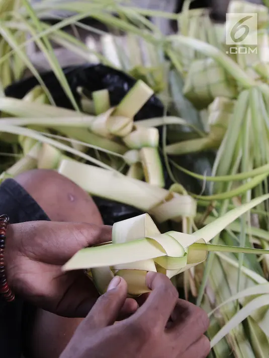 Pedagang membuat kulit ketupat siap jual di Pasar Kemiri Muka, Depok, Jawa Barat, Selasa (12/6). Pedagang membanderol satu ikat kulit ketupat isi 10 dengan harga Rp 10 ribu. (Liputan6.com/Herman Zakharia)