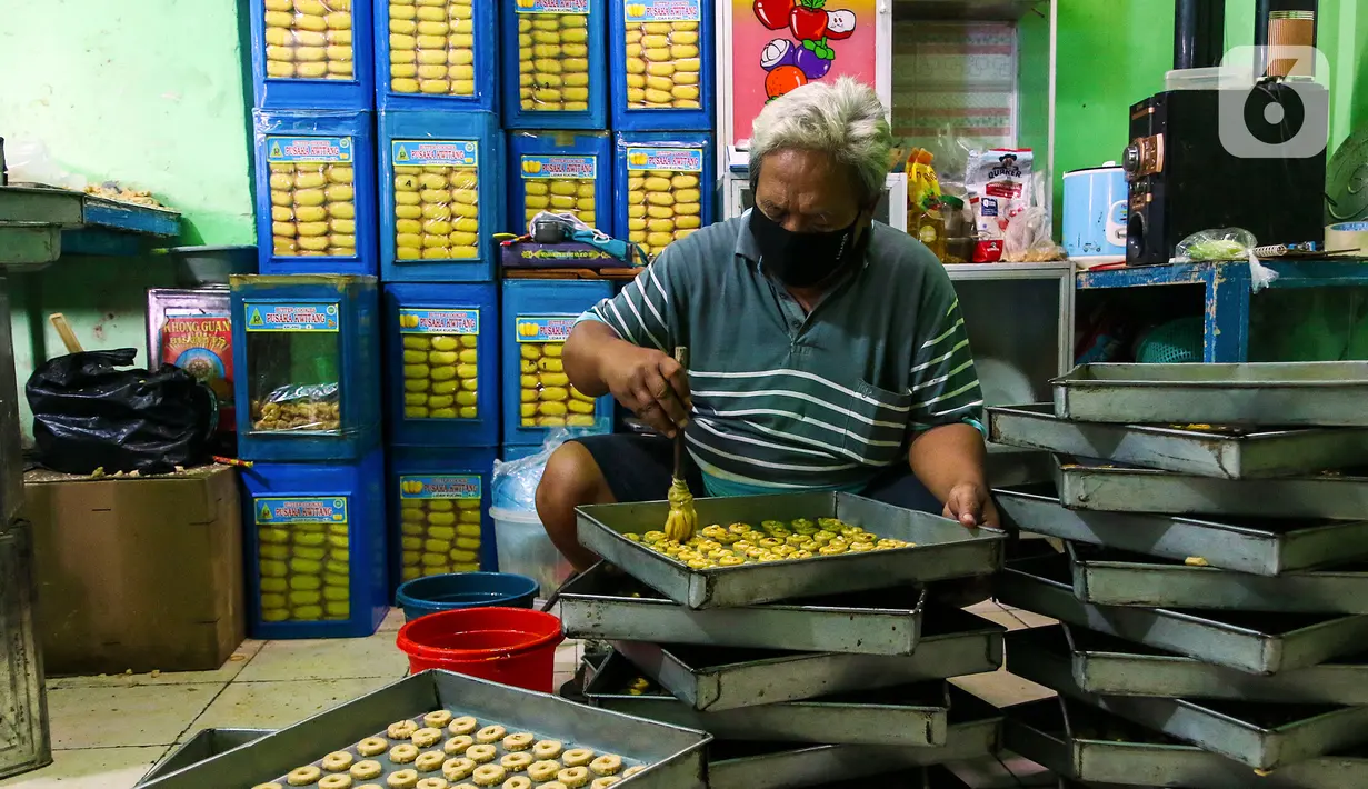 Seorang pekerja membuat kue di industri pembuatan kue kering Pusaka Kwitang, Jakarta, Kamis (30/4/2020). Kue kering yang dijual seharga Rp480 ribu per kaleng itu pada bulan Ramadan tahun ini mengalami penurunan produksi hingga 500 kaleng akibat pandemi COVID-19. (Liputan6.com/Johan Tallo)