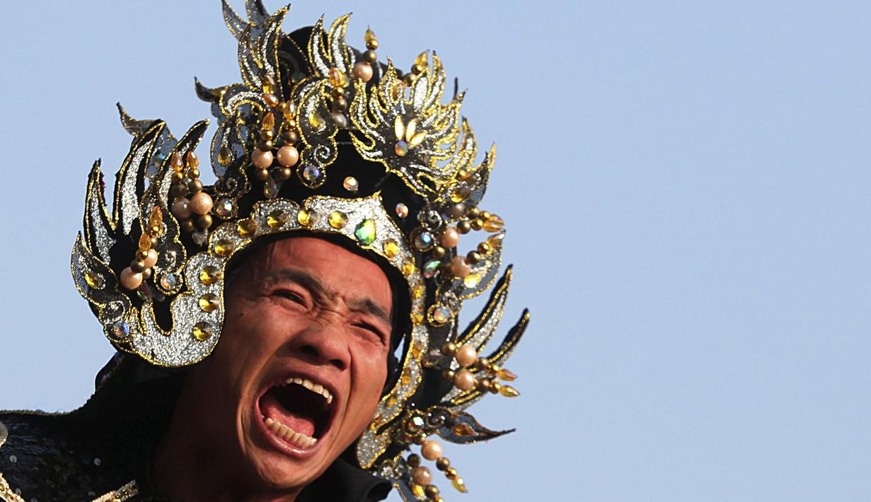 Seorang umat Tionghoa saat mengikuti rangkaian acara Hei Neak Ta atau parade roh untuk memperingati Cap Go Meh, Kamboja, (21/2). (REUTERS/Samrang Pring)