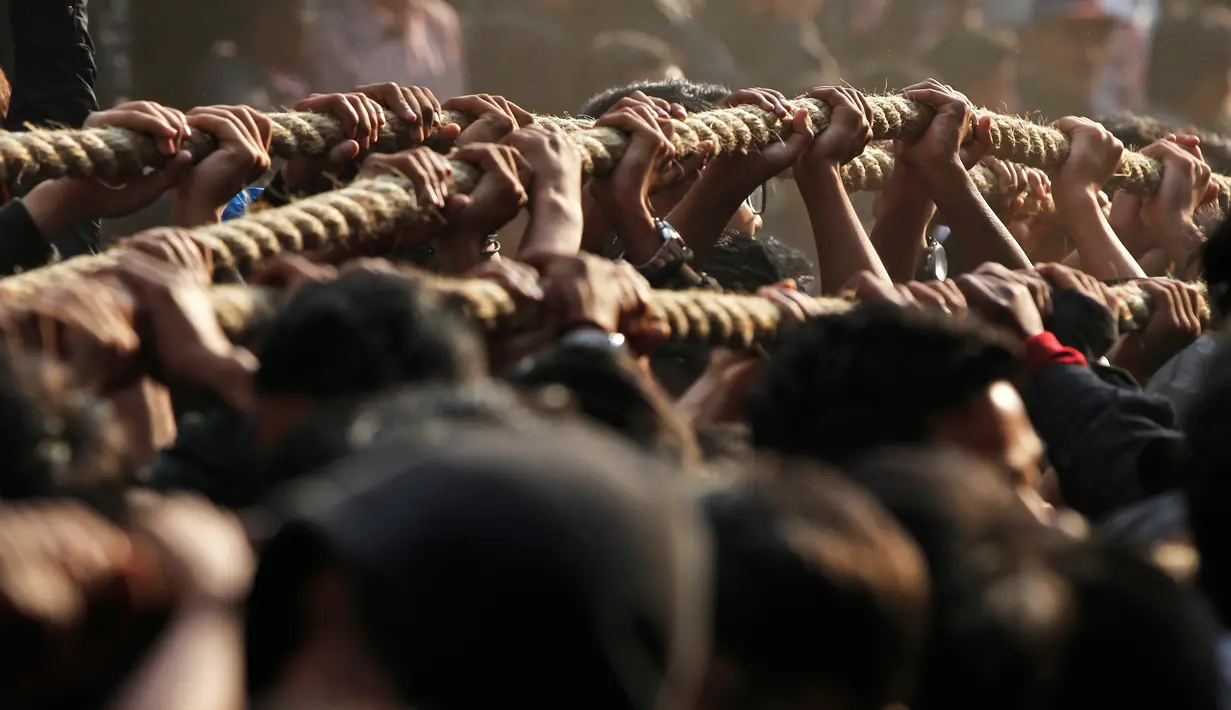 Sejumlah umat Hindu Nepal bahu membahu menarik kereta kayu dewa Bhairava saat festival Bisket Jatra di Bhaktapur, Nepal (10/4). Festival ini diadakan untuk menandai Tahun Baru Nepal. (AP Photo/Niranjan Shrestha)