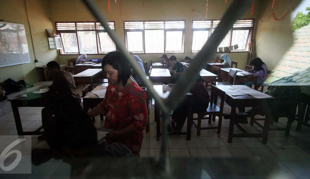 Seorang pengawas mengecek absensi peserta  saat ujian kesetaraan Paket C di SMPN 15 Yogyakarta, Senin (4/4). Sebanyak 447 peserta mengikuti ujian akhir untuk mendapatkan ijazah setingkat SMA. (Liputan6.com/Boy Harjanto)