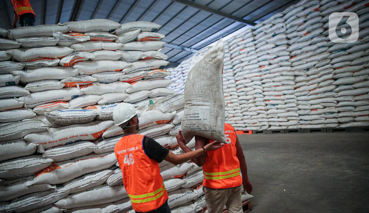 Pekerja membawa beras milik Perum Bulog di kawasan Pulo Mas, Jakarta, Kamis (26/11/2020). Kementan kembali memastikan bahwa meski tengah dilanda pandemi Covid-19 pasokan beras hingga akhir tahun masih ada stok beras sebanyak 7,1 juta ton. (Liputan6.com/Faizal Fanani)