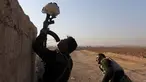 Seorang tentara Irak menggunakan senapan untuk menahan helm sebagai umpan dalam bentrokan dengan militan ISIS di Al-Qasar, Tenggara Mosul, Irak (28/11). (REUTERS/Goran Tomasevic)