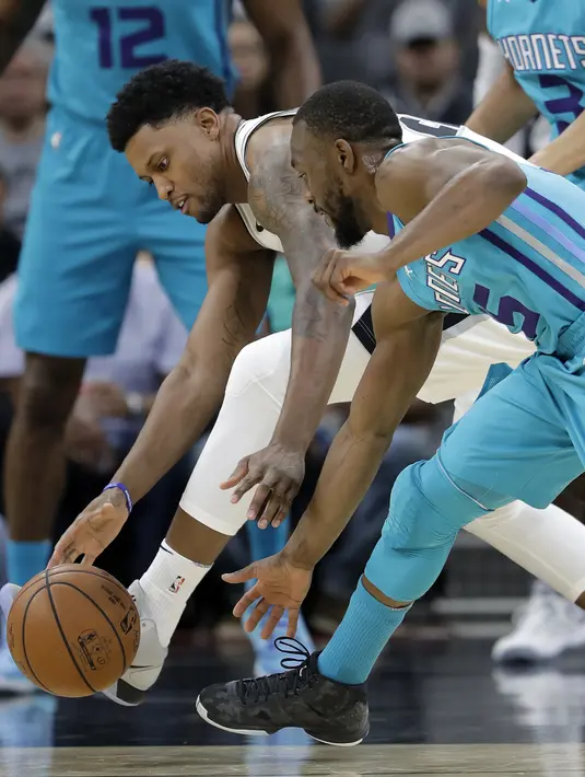 Pemain San Antonio Spurs, Rudy Gay (kiri) berebut bola dengan pemain Charlotte Hornets, Kemba Walker pada laga NBA basketball game di AT&T Center, San Antonio, (3/11/2017) waktu setempat. San Antonio menang 108-101. (AP/Eric Gay)