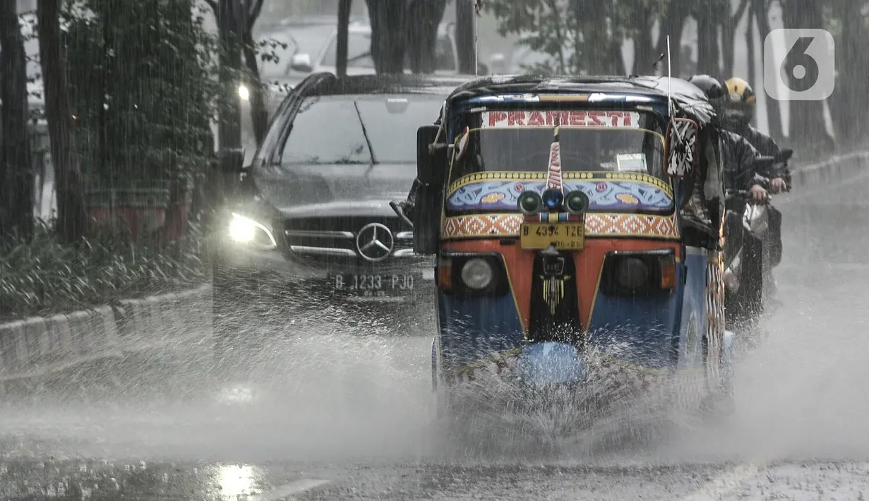Bajaj saat menerobos hujan di Jalan Pramuka, Jakarta, Kamis (18/2/2021). Badan Meteorologi Klimatologi dan Geofisika (BMKG) mengimbau pengguna jalan agar berhati-hati saat berkendara karena hujan disertai angin kencang diprediksi terus berlanjut hingga akhir Februari. (merdeka.com/Iqbal S Nugroho)