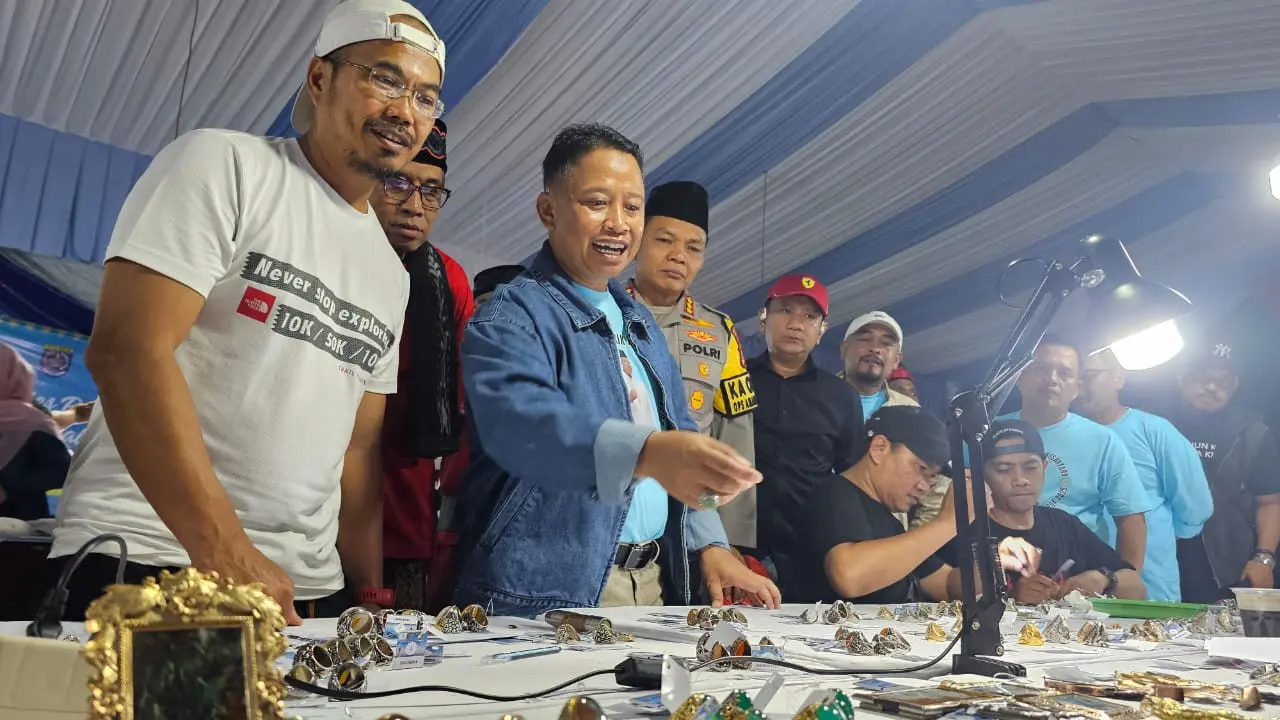 Wali Kota Depok, Supian Suri saat melihat koleksi batu akik milik para kolektor pada kontes batu akik Nusantara di lapangan DOS Balai Kota Depok. (Liputan6.com/Dicky Agung Prihanto)