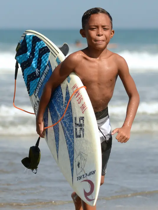 Natan Bontje selama latihan di pantai Kuta dekat Denpasar di pulau resor Indonesia Bali (6/5). Natan berusia sembilan tahun merupakan peserta termuda yang mengikuti kompetisi Asian Surfing Tour 2018 yang telah berakhir. (AFP Photo/Sonny Tumbelaka)