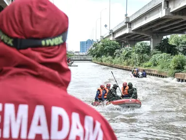 Petugas gabungan mengevakuasi korban dengan perahu karet saat simulasi penanganan banjir di Kalimalang, Cipinang Melayu, Rabu (17/11/2021). Simulasi digelar dalam rangka kesiapsiagaan petugas dalam penanganan korban banjir, terutama evakuasi warga yang terpapar Covid-19 (merdeka.com/Iqbal S Nugroho)