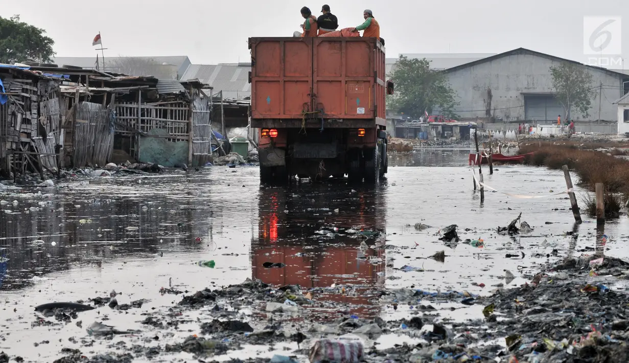 Petugas UPK Badan Air Dinas Lingkungan Hidup DKI Jakarta membawa sampah dari Kampung Bengek, Muara Baru, Penjaringan, Jakarta, Rabu (4/9/2019). Setelah viral dan menjadi sorotan, lautan sampah yang memenuhi tanah garapan milik PT Pelindo II tersebut mulai dibersihkan. (merdeka.com/Iqbal Nugroho)