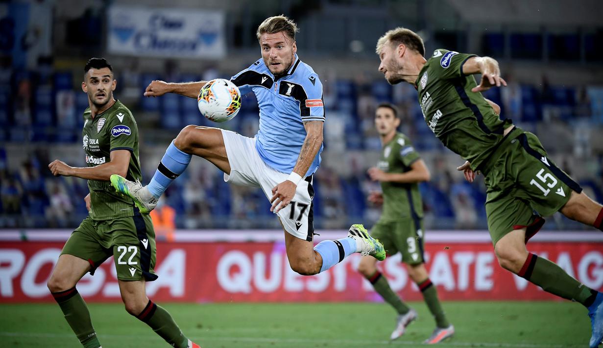 Penyerang Lazio, Ciro Immobile, berebut bola dengan bek Cagliari, Ragnar Klavan, pada laga lanjutan Serie A pekan ke-35 di Stadio Olimpico, Jumat (24/7/2020) dini hari WIB. Lazio menang 2-1 atas Cagliari.(AFP/Filippo Monteforte)