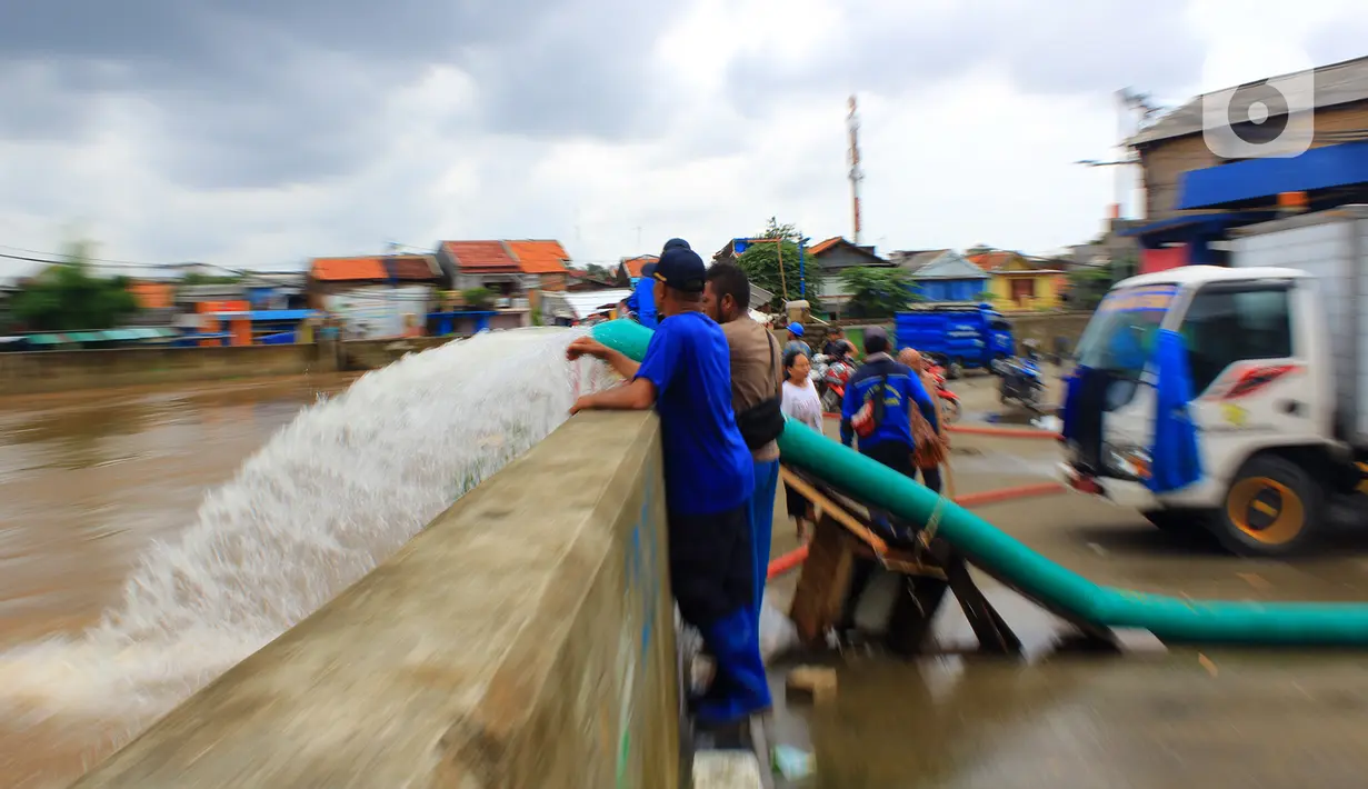 Petugas Sudin Sumber Daya Air (SDA) membuang air ke kali Ciliwung saat banjir yang merendam kawasan Kampung Melayu Kecil, Bukit Duri, Jakarta, Selasa (25/2/2020). Banjir tersebut akibat luapan sungai Ciliwung. (merdeka.com/magang/ Muhammad Fayyadh)