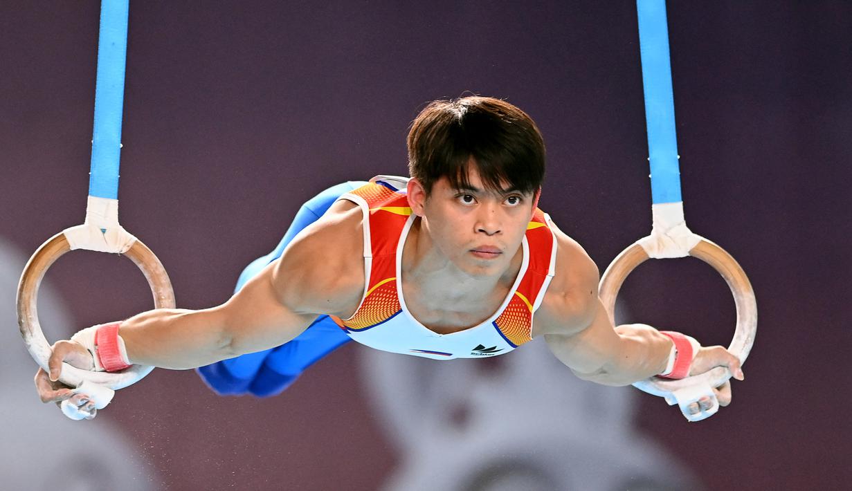 Carlos Yulo dari Filipina berkompetisi dalam nomor gelang-gelang cabang olahraga senam artistik Pesta Olahraga Asia Tenggara (SEA Games) ke-32 di Phnom Penh, Kamboja, Selasa (9/5/2023). (Photo by Tang Chhin Sothy / AFP)