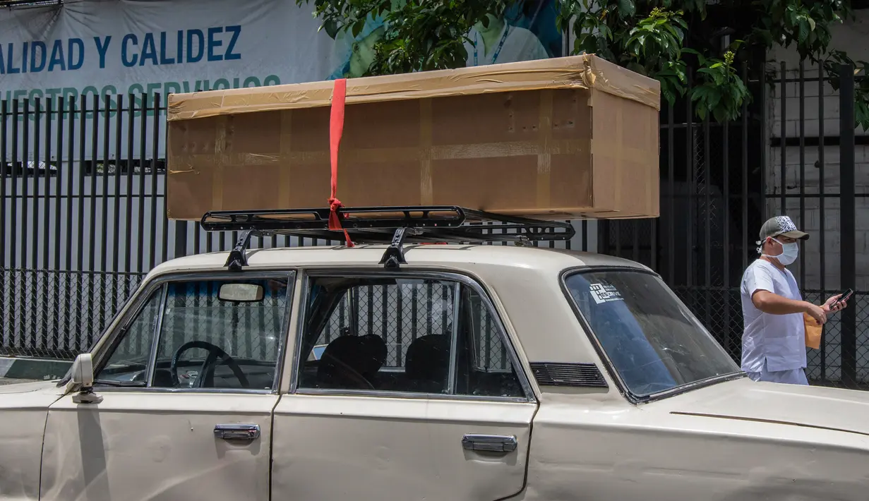 Peti mati kardus berisi jenazah diletakkan di atas mobil sebelum dimakamkan di luar Rumah Sakit Teodoro Maldonado di Guayaquil, Senin (6/4/2020). Kehabisan peti mati, kota terbesar di Ekuador yang menjadi klaster wabah virus corona itu menggunakan kotak kardus untuk korban Covid-19. (AP/Luis Perez)