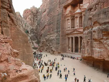 Wisatawan jalan-jalan saat mengunjungi kota arkeologi Petra, Yordania, Kamis (21/11/2019). Petra ditetapkan sebagai salah satu dari Tujuh Keajaiban Dunia Baru oleh Yayasan New7Wonders pada tahun 2017. (AHMAD ABDO/AFP)