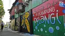 Anak sekolah berjalan di antara tembok warna-warni di Kampung Pelangi, Johar Baru, Jakarta, Rabu (2/5). Wilayah ini disebut Kampung Pelangi setelah warga dibantu petugas PPSU mempercantik gang dan tembok rumah dengan gambar. (Merdeka.com/Iqbal Nugroho)