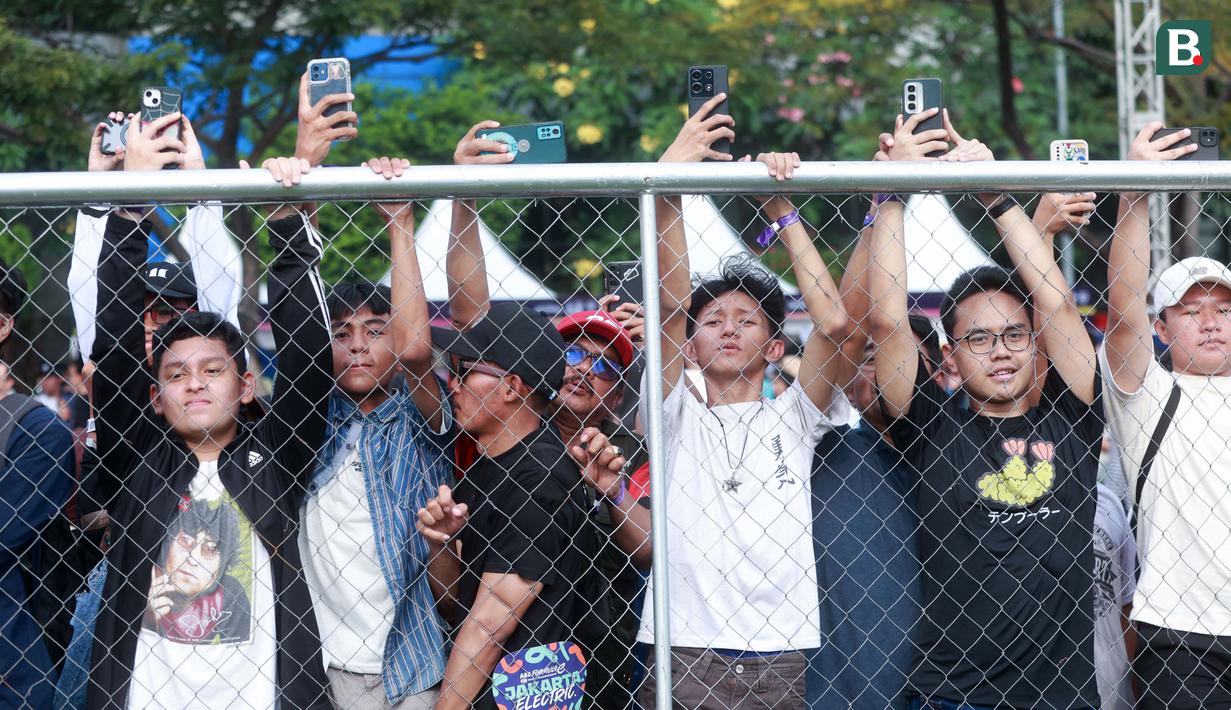 Sejumlah penonton berusaha merekam dengan gawainya saat ajang Jakarta E-Prix 2025 yang berlangsung di Jakarta International ePrix Circuit, Ancol, Sabtu (21/6/2025). (Bola.com/M Iqbal Ichsan)
