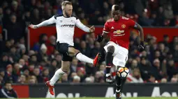 Pemain Manchester United, Paul Pogba (kanan) berusaha melewati adangan pemain Derby County, Johnny Russell pada laga PIala FA di Old Trafford, Manchester, (5/1/2018). Manchester United menang 2-0. (Martin Rickett/PA via AP)