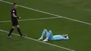 Wasit Raphael Claus (kiri) menyaksikan kiper timnas Iran Alireza Beiranvand terbaring di tanah usai mengalami cedera saat pertandingan sepak bola grup B Piala Dunia Qatar 2022 antara Inggris dan Iran di Stadion Internasional Khalifa, Doha, Qatar, Senin (21/11/2022). Meski mengalami cedera yang cukup parah, Beiranvand masih sempat berdiri dan mencoba melanjutkan pertandingan. (AP Photo/Pavel Golovkin)