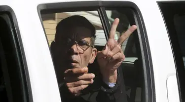 Pembajak pesawat EgyptAir, Seif Eldin Mustafa mengacungkan dua jarinya saat berada di dalam mobil tahanan di sebuah pengadilan di Larnaca, Siprus, Rabu (30/3). Seif Eldin Mustafa menyerahkan diri dan membebaskan 5 sandera. (REUTERS/Yiannis Kourtoglou)
