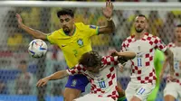 Pemain Timnas Kroasia, Luka Modric (depan) dilanggar pemain Timnas Brasil, Lucas Paqueta dalam laga babak perempatfinal Piala Dunia 2022 di Education City Stadium, Al Rayyan, Qatar, Jumat (9/12/2022) malam WIB. (AP/Frank Augstein)