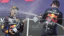 Pembalap Red Bull, Max Verstappen (kanan) merayakan kemenangan dengan menyemprotkan sampanye ke arah rekannya, Sergio Perez setelah Formula 1 GP Jepang 2024 di Sirkuit Suzuka, Jepang, Sabtu (07/04/2024). (AP Photo/Hiro Komae)