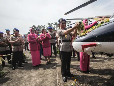 Kapolri Jenderal Tito Karnavian  dan Istri Tri Suswati menyiramkan kembang saat menyerahkan dua helikopter jenis Bell 429 IGW dari PT Multi Pasific California usai menghadiri  HUT Korpolairud ke-67, Tangerang, Selasa (5/11). (Liputan6.com/Faizal Fanani)
