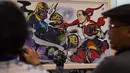 Pengunjung melihat  gambar komik yang menunjukkan Presiden Indonesia Joko Widodo, sebagai karakter Avenger versus Thanos di Festival Pop Culture Popcon Asia 2018 di BSD, Tangerang Selatan, Sabtu (22/9). (AFP PHOTO / BAY ISMOYO)