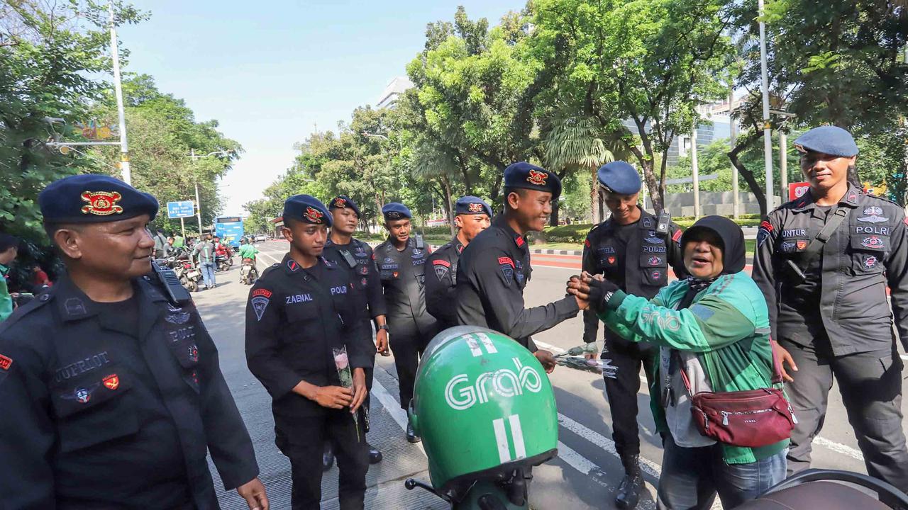 FOTO: Aksi Damai Ojol Tebar Mawar untuk Perdamaian