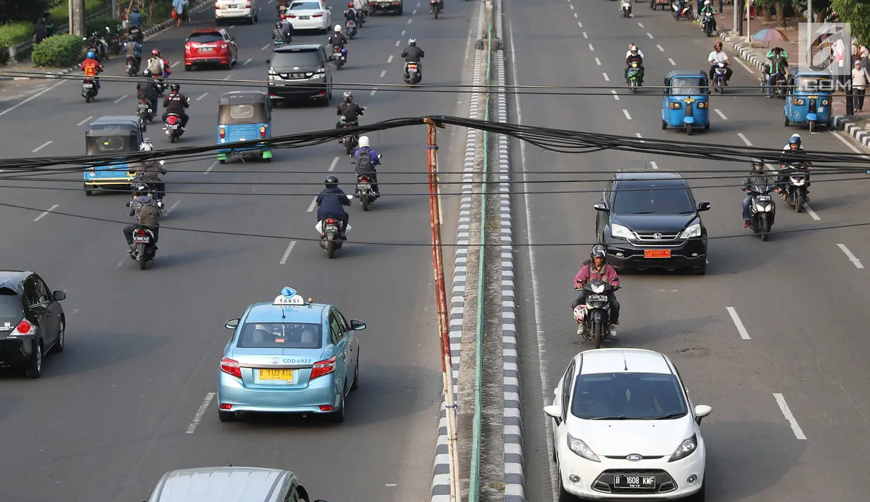 Sejumlah pengendara melintas dibawah kabel yang ditopang tiang bambu di kawasan Pasar Baru, Jakarta, Selasa (12/9). Selain membahayakan pengguna jalan, buruknya instalasi kabel tersebut juga merusak estetika kota. (Liputan6.com/Immanuel Antonius)