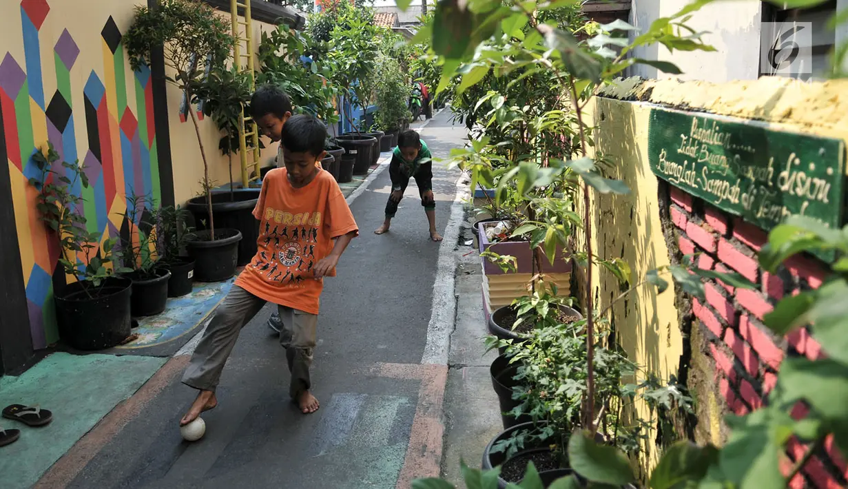 Anak-anak bermain bola di antara tembok warna-warni di Kampung Pelangi, Johar Baru, Jakarta, Rabu (2/5). (Merdeka.com/Iqbal Nugroho)