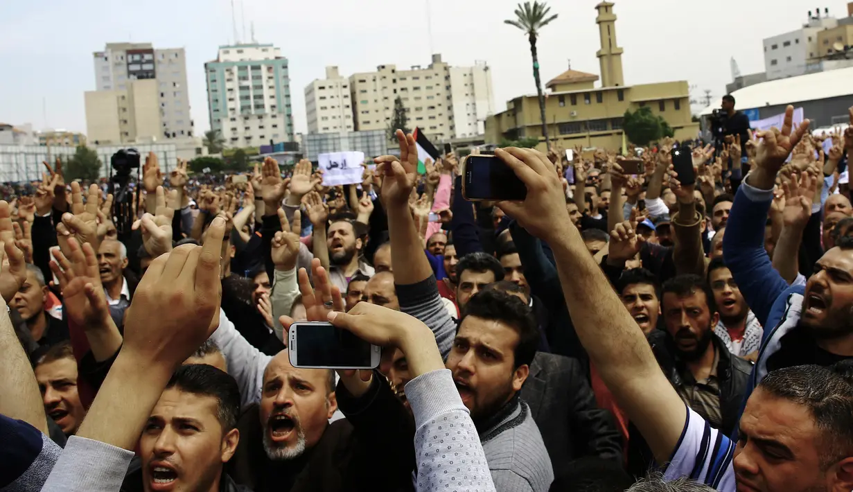 Pekerja Otoritas Palestina menggelar unjuk rasa di alun-alun Kota Gaza, Sabtu (8/4). Aksi ini sebagai bentuk protes melawan kebijakan Otoritas Palestina yang memotong jumlah gaji secara drastis untuk para pekerja di Gaza. (AP Photo/Adel Hana)