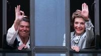 Presiden Amerika Serikat Ronald Reagan dan istrinya, Nancy Reagan  melambaikan tangan dari jendela rumah sakit tempatnya dirawat pada 18 Juli 1985 (AP Photo)