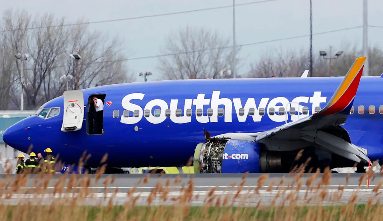 Pesawat Southwest Airlines mendarat darurat di Bandara Internasional Philadelphia akibat kerusakan pada mesin, Selasa (17/4). Pesawat jenis Boeing 737 itu mendarat darurat dengan tutup mesin kiri sobek. (David Maialetti /The Philadelphia Inquirer via AP)