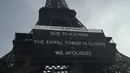 Sebuah papan memperingatkan tentang pemogokan di Menara Eiffel, Paris, Rabu (27/12/2023). (AP Photo/Lewis Joly)