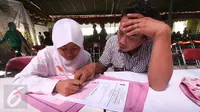 Siswi didampingi orangtuanya mengisi formulir Penerimaan Peserta Didik Baru (PPDB) di Dinas Pendidikan Kota Yogyakarta, Rabu (15/6). PPDB jalur pemegang Kartu Menuju Sehat (KMS) diminati siswa untuk mendapatkan sekolah favorit. (Liputan6.com/Boy Harjanto)