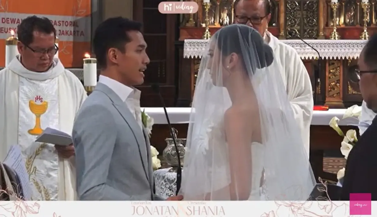 Berdiri berhadapan sambil memegang tangan. "Saya Leonardo Jonatan Christie memilih engkau, Shania Junianatha, menjadi istri saya. Saya berjanji untuk setia mengabdikan diri padamu, dalam untung dan malang, diwaktu sehat maupun sakit, saya mau mengasihi dan menghormati engkau sepanjang masa hidup saya," kata Jojo seperti dilansir dari Youtube Viding. [Youtube/Viding]