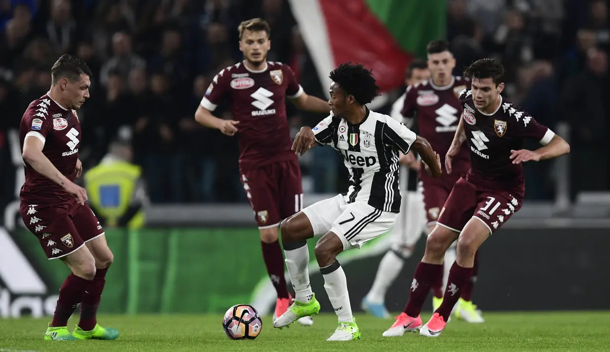 Gelandang, Juventus, Juan Cuadrado, berusaha melewati beberapa pemain Torino. Dalam pertandingan tersebut kedua tim memakai formasi 4-2-3-1. (AFP/Miguel Medina)