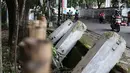 Pengendara sepeda motor melintasi pagar yang ambruk di Taman Hutan Tebet, Jakarta, Kamis (28/3). Kondisi pagar yang ambruk akibat hujan deras tersebut butuh perbaikan karena telah terabaikan selama beberapa bulan terakhir. (Liputan6.com/Immanuel Antonius)