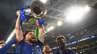 Selebrasi striker Chelsea, Olivier Giroud bersama trofi Liga Champions setelah laga final Liga Champions 2020/2021 menghadapi Manchester City di Dragao Stadium, Porto (29/5/2021). Bersama Chelsea pada musim 2020/2021, Olivier Giroud hanya tampil satu kali pada leg kedua semifinal Liga Champions menghadapi Real Madrid walau hanya satu menit. Chelsea pun lolos ke final hingga akhirnya juara usai mengalahkan Man City di mana Olivier Giroud hanya duduk di bangku cadangan. (AFP/Pool/David Ramos)