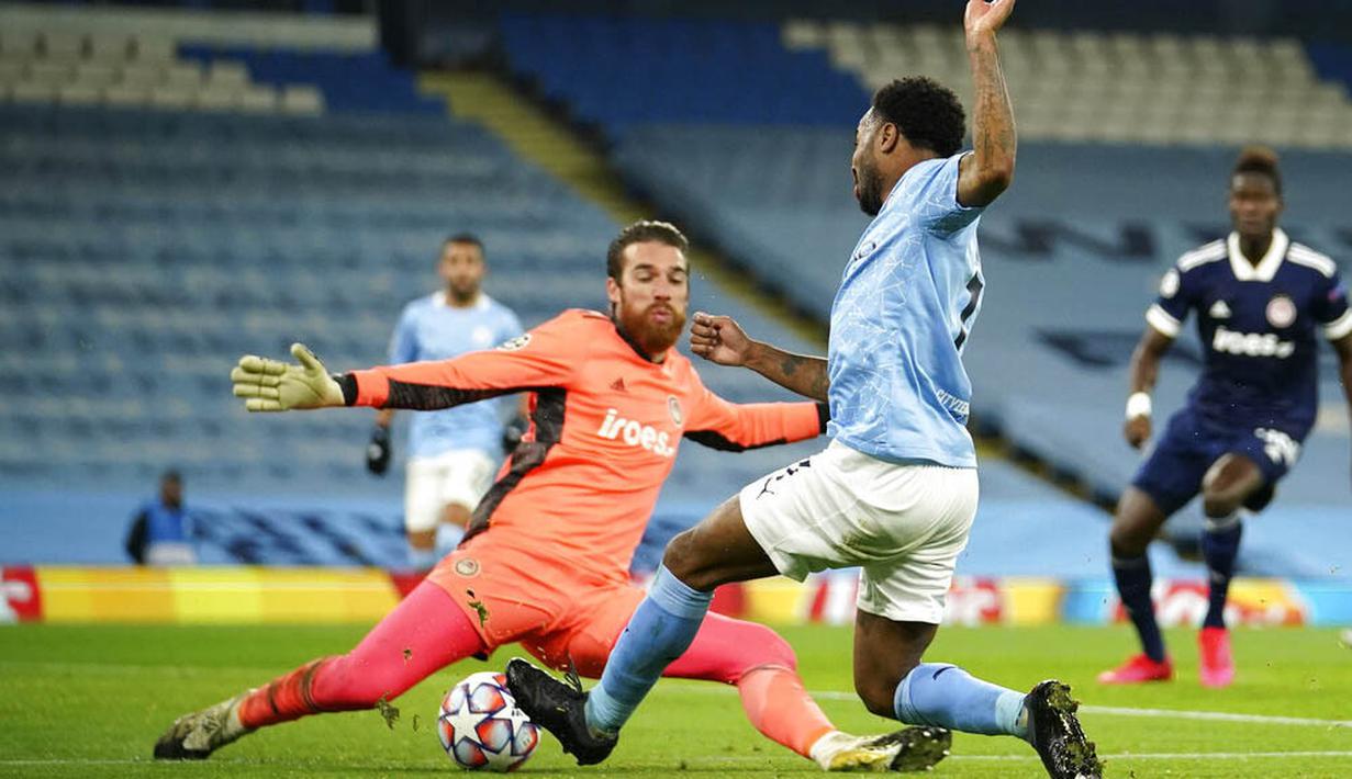 Kiper Olympiakos, Jose Sa, berusaha menghalau tendangan striker Manchester City, Raheem Sterling, pada laga Liga Champions di Stadion Etihad, Rabu (4/11/2020). Manchester City menang dengan skor 3-0. (AP/Dave Thompson)