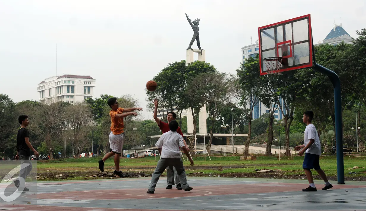 Sejumlah pelajar bermain basket di Kawasan Lapangan Banteng, Jakarta, Senin (29/8). Pemprov DKI Jakarta berencana melakukan desain ulang Lapangan Banteng, sehingga Monumen Pembebasan Irian Barat bisa lebih terlihat. (Liputan6.com/Helmi Fithriansyah)
